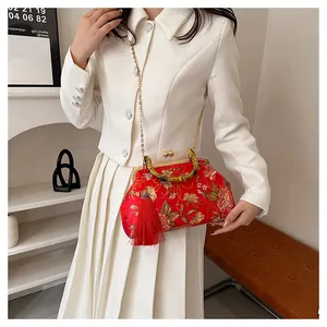 Detail of red floral embroidered satin bag with bamboo handle and red tassels