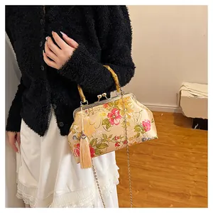 Detailed macro view of the bamboo handle and floral embroidery on the silk crossbody bag