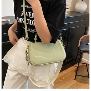 Détail du sac à rabat vert menthe avec coutures ondulées et deux bandoulières