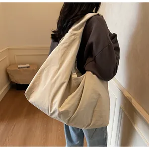 Borsa hobo minimalista in nylon beige mostrata in un elegante ambiente interno luminoso