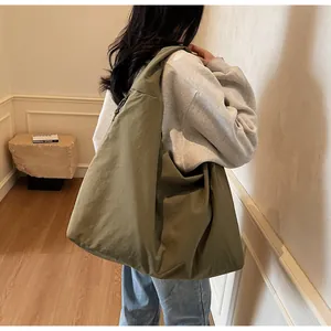 Vista laterale della borsa hobo oversize in nylon verde oliva con tracolla larga
