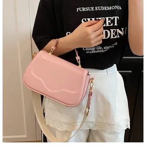 Détail du sac à main rose avec rabat gaufré à vagues et large bandoulière ajustable