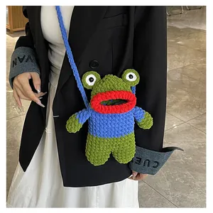 Detail of green knitted frog crossbody bag showing handmade yarn texture and shoulder strap