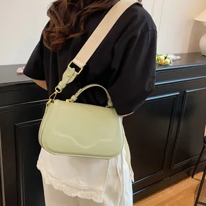 Sac à main vert menthe en PU avec large bandoulière, vue latérale sur modèle