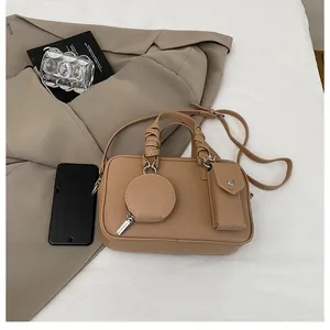 Détail du sac à main en cuir camel grainé avec mini pochettes et anses enroulées