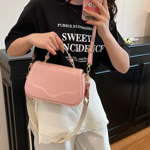 Sac à main rose en cuir PU avec large bandoulière et finitions métalliques dorées