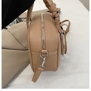 Détail du sac kaki grainé avec poignée tressée et fermeture éclair argentée