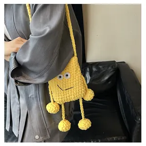 Model wearing a yellow crochet knit crossbody phone bag with cute cartoon frog face features