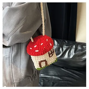 Handmade crochet mushroom house crossbody bag with detailed knit texture and red cap