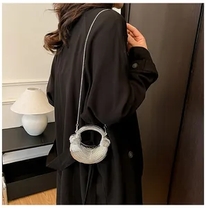 Gros plan d'un sac demi-lune argenté avec poignée anneau et finition en métal texturé