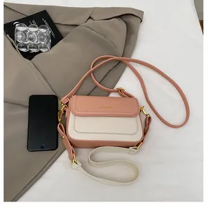 Détails du petit sac bandoulière rose et crème avec texte doré et deux types de sangles