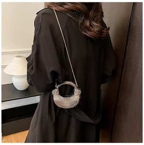 Vue de dos d'un modèle portant un mini sac croissant argenté avec chaîne et poignée ronde