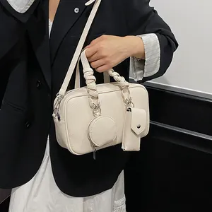 Sac bandoulière chic beige en cuir grainé avec poignée froncée et charms
