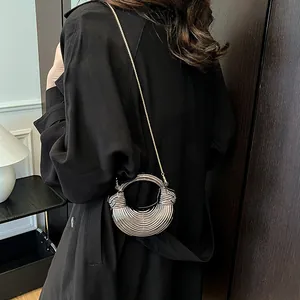 Sac croissant métallique argenté avec texture ondulée et poignée ronde pour fête
