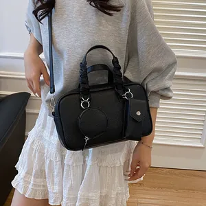 Sac à main noir à motif litchi avec poignée tressée et poches amovibles sur mannequin