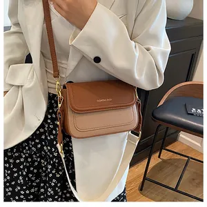 Détail du sac en cuir grainé avec deux bandoulières et design bicolore contrasté