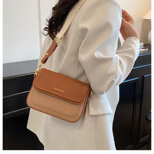 Détail du sac beige et marron en cuir grainé avec inscription dorée fashion élégante