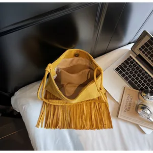 Detalle del interior del bolso bohemio amarillo con flecos y bolsillo interno con cremallera