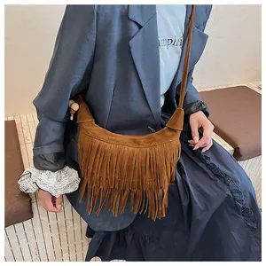 Close-up of brown suede moon bag with dense fringe detail and stylish knotted shoulder strap