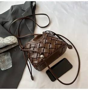 Détail de la sacoche tressée marron foncé avec ornements de perles métalliques