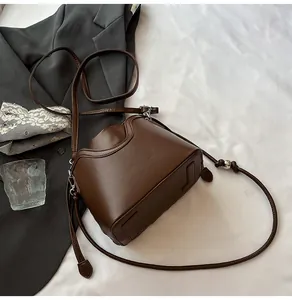 Détail du sac seau marron foncé avec boules métalliques argentées et clous de protection