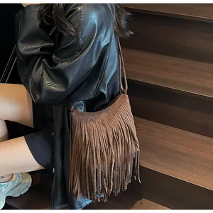 Brown suede shoulder bag with long fringe tassels shown on a model in retro style