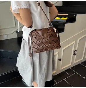 Détail du sac seau tressé marron foncé avec fermeture à cordon et bandoulière réglable