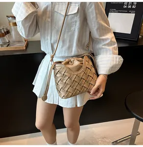 Détail du sac seau tissé kaki avec fermeture à cordon et bandoulière en cuir souple