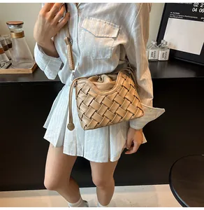 Détail du sac seau tissé beige en cuir avec fermeture à cordon sur le mannequin