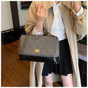 Detail of grey quilted fabric and black leather contrast with gold twist lock