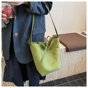 Détail du sac seau vert avocat dépoli avec cordon en cuir et finition texturée