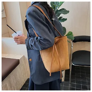Gros plan du sac seau marron mat avec de longues bretelles sur un mannequin