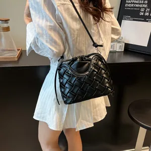 Sac seau tressé en cuir noir minimaliste avec cordon de serrage en situation réelle