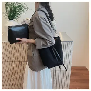 Détail du sac seau noir mat avec pochette intérieure et bandoulière porté par un mannequin