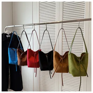 Détails des sacs seau en daim coloré en bleu ciel, camel, rouge, noir et vert olive