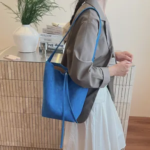 Sac seau minimaliste en daim bleu Klein avec cordon de serrage et bandoulière fine