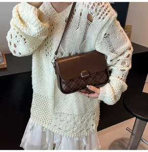Détail du sac tressé marron foncé avec rabat lisse et bouton-pression métallique chic