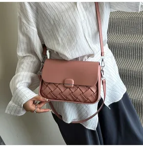 Détail du sac à bandoulière en cuir tressé rose poudré avec rabat lisse et crochet