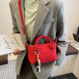 Borsa a tracolla rossa minimalista in pelle scamosciata con nappa di perline e nodo