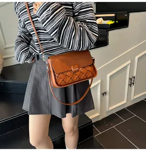 Détails d'un sac à bandoulière tressé caramel avec texture large et fermeture à rabat