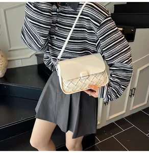 Détail du sac bandoulière crème avec design patchwork tissé et bandoulière
