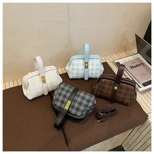 Detalle de bolsos con diseño de cuadros, cierres metálicos y correas de piel ajustables