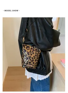 Détail du sac bandoulière léopard avec plaque dorée et fine lanière en cuir noir