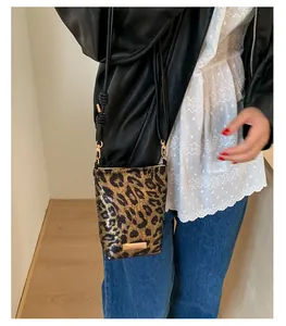 Détail du sac de téléphone léopard avec fini métallisé et accents dorés chic