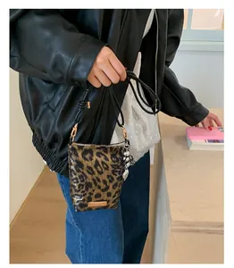 Détail d'un sac téléphone léopard avec texture imitation crin et pendentifs métalliques chic