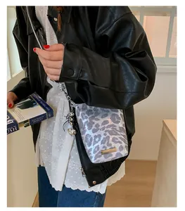 Sac bandoulière moderne avec imprimé léopard bleu et chaîne argentée sur modèle