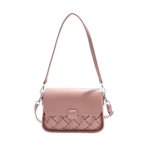 Sac hobo rose en cuir tressé avec boucle argentée et bandoulière sur fond blanc