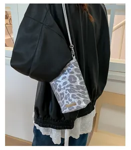 Détail du sac de téléphone léopard argenté avec finition métallique et logo en métal
