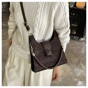 Détail de la texture serpent marron et de la boucle carrée sur le sac à bandoulière en cuir