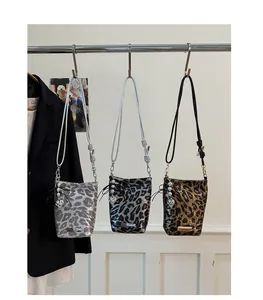 Détail de mini sacs bandoulière imprimé léopard en argent, anthracite et bronze